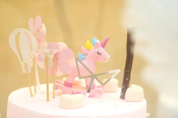 Birthday cake with pink unicorn, bokeh background