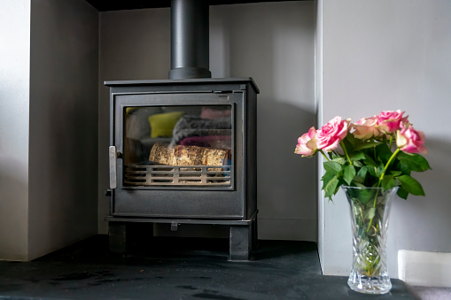 Wood burner and vase of roses in a modern British house.
