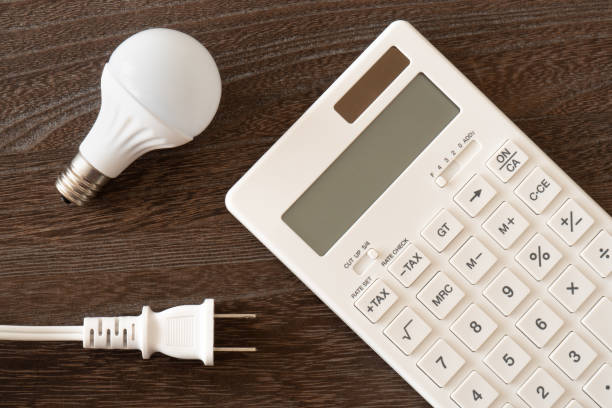 istock Concept of electricity charge (light bulb, calculator and plug) 1304718735