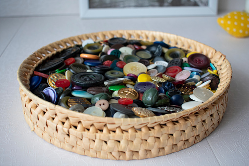 Wicker basket full of vintage colored buttons