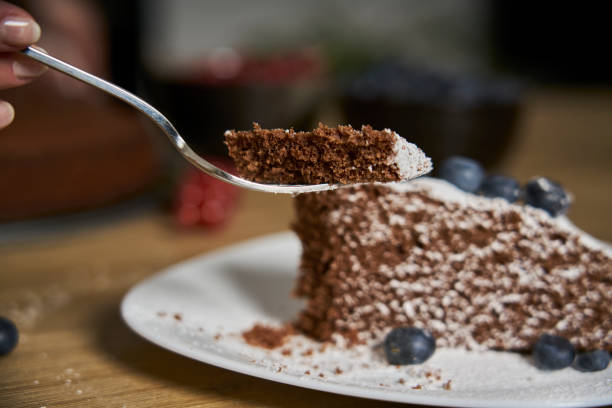 istock Tasting a slice of chocolate cake with a fork. 1304719741