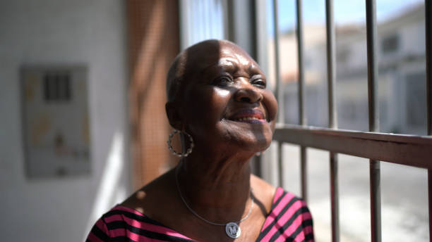 istock Senior woman looking through the window at home 1304719988