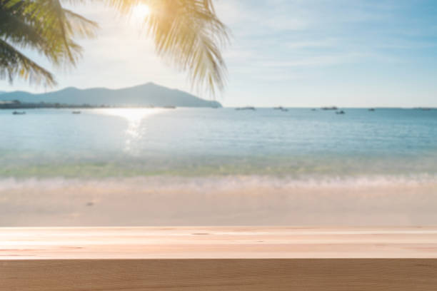 istock Beautiful tropical sand beach with empty wooden table and copy space, Summer vacation concept 1304721053