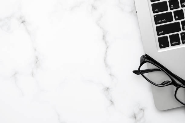 istock White marble office desk table with laptop computer and eye glasses. Top view with copy space, flat lay. 1304721985