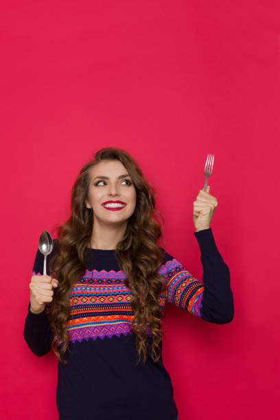 istock Smiling Young Woman Is Holding Fork And Spoon 1304723310
