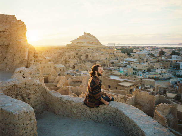 Woman looking at scenic view of Siwa oasis at sunset Woman looking at scenic view of Siwa oasis at sunset cairo africa egypt built structure stock pictures, royalty-free photos & images