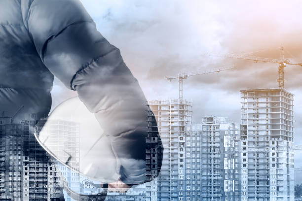 istock Workplace safety concept. Silhouette of an engineer, architect, builder on the background of buildings under construction. Multi-exposure. 1304724955