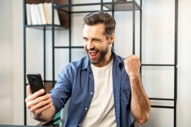 istock Excited lucky bearded guy looking at mobile phone 1304724961