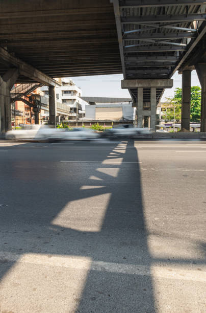 istock construction pier under highway while vehicle movement on road with shadow lighting on under cross bridge 1304725965
