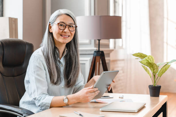 istock Confident middle-aged businesswoman using tablet at work place in office 1304726282