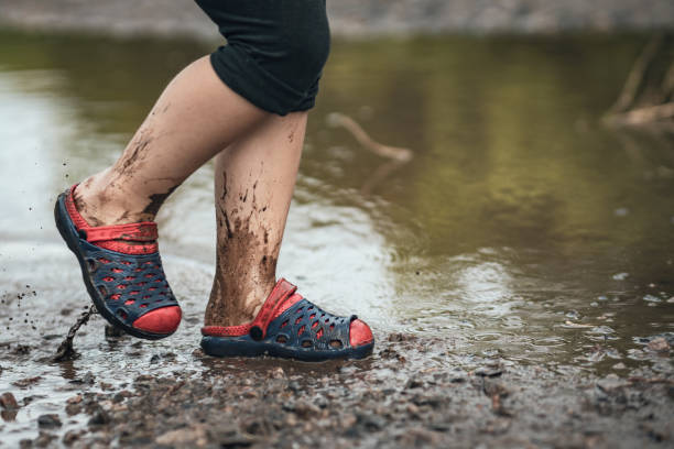 istock Children's feet walking in a muddy puddle after the rain 1304727256