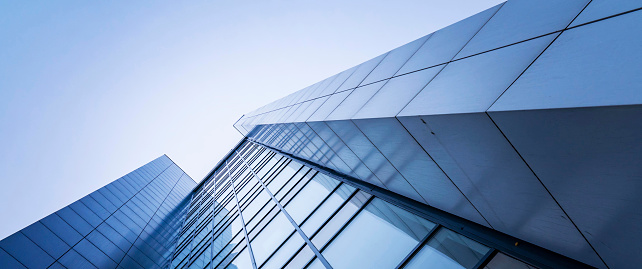 perspective, the skyscraper is directed to the sky. blue gradient, light reflection in glass, urban building design.