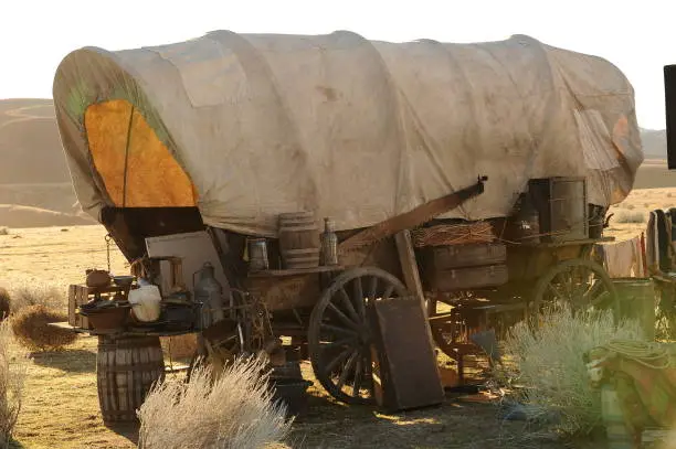 A covered wagon set up out on the prairie out west on the Oregon Trail.