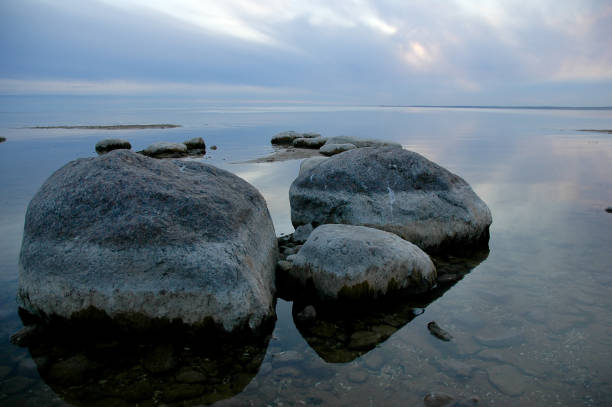 istock Sunrise on the lake, tranquil water and boulder beach 1304733175