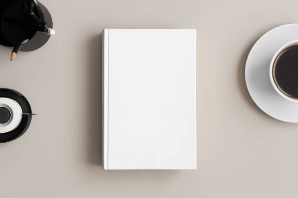 istock White book mockup with a coffee and workspace accessories on a beige table. 1304736023