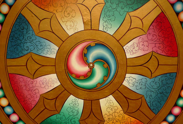 le dharmachakra est souvent utilisé comme décoration dans les temples bouddhistes. c’est la ronde sans commencement des renaissances avec la roue à huit rayons représentant le noble chemin huit fois - tibetan buddhism photos et images de collection