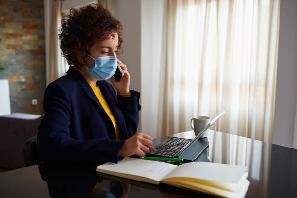 istock Woman working from home with a face mask 1304738525
