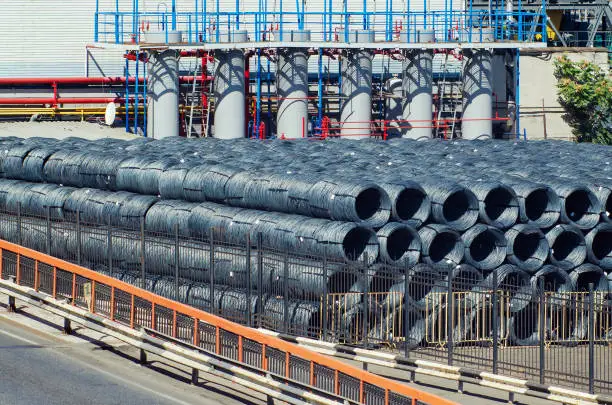 Import or export of rolled metal products. Coils of steel wire in a warehouse in the seaport.