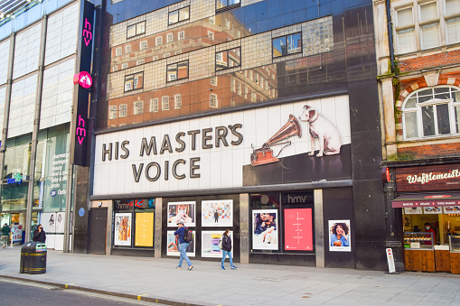 London, United Kingdom - February 26 2021: People walk past the HMV flagship store on Oxford Street, which closed permanently in 2019.
