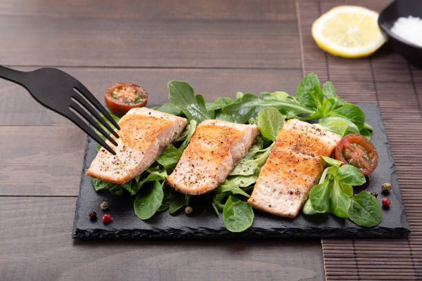 istock fork pricking Salmon fillets on slate dish on wooden table background 1304741863