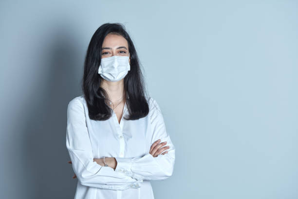 istock Businesswoman with protective face mask on plain background. 1304742889