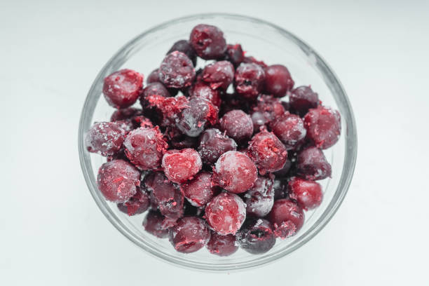 istock Frozen cherries in a glass bowl top view on white background 1304742980