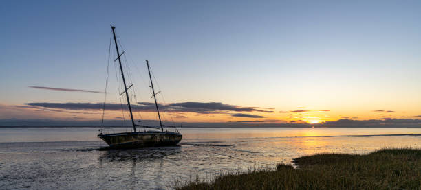 Ship Wreck with beautiful sunset An abandoned sail boat which has been left to rot on the North West coast of the UK lytham st. annes stock pictures, royalty-free photos & images