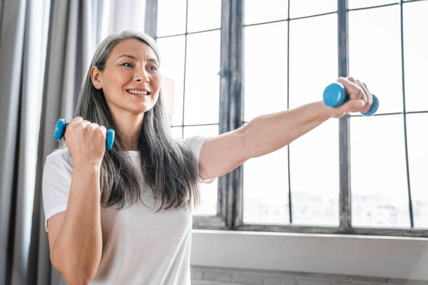 istock Side view shot of a middle-aged woman doing exercises with dumbbells 1304744708