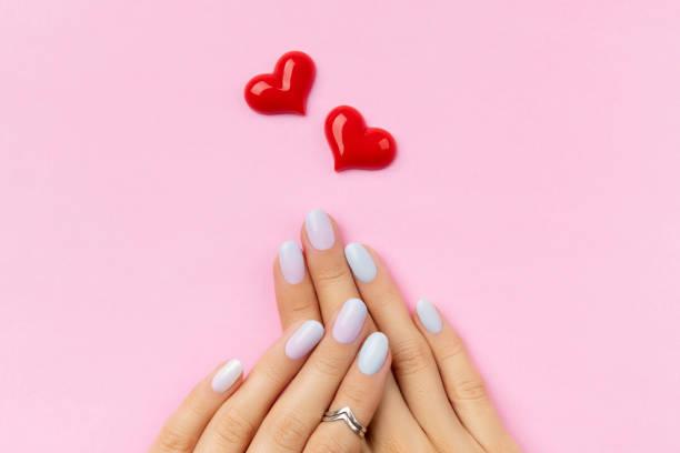 istock Womans hands with trendy manicure on pink background. Summer nail design 1304744811