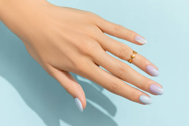 manos de mujer con manicura de moda sobre fondo azul. diseño de uñas de verano - anillo joya fotografías e imágenes de stock