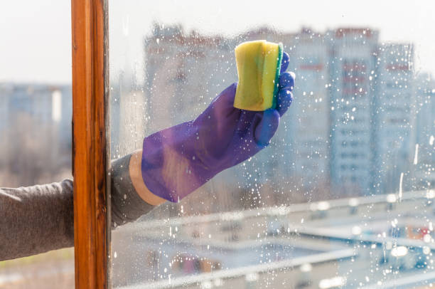 istock A woman's hand in a blue glove washes the window 1304745762