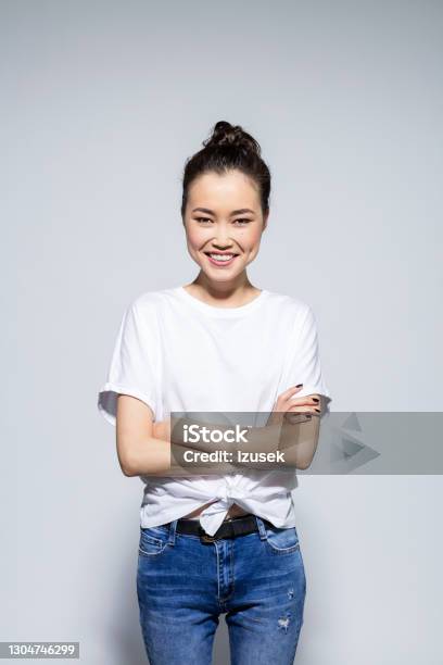 Friendly Asian Young Woman Standing With Arms Crossed Stock Photo - Download Image Now