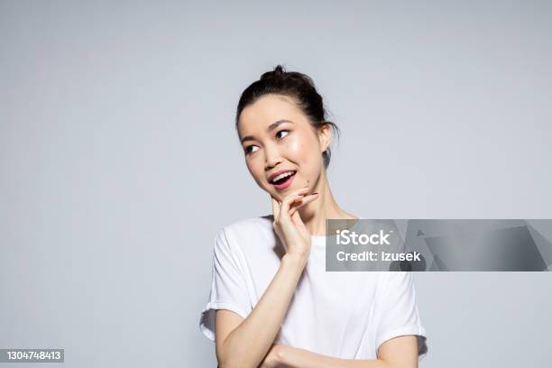 Portrait Of Surprised Young Woman Stock Photo - Download Image Now - Women, Gray Background, Portrait