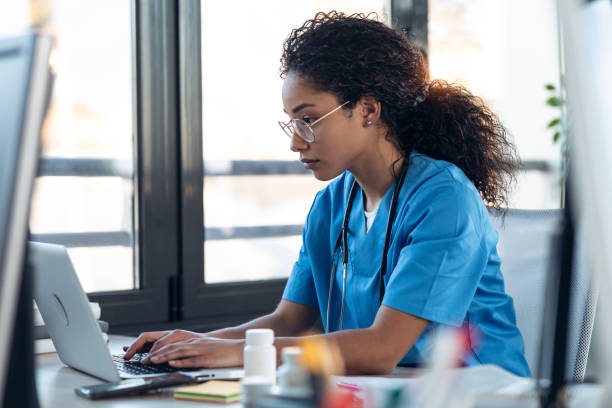 istock Attractive young afro female doctor talking working with her computer in the consultation. 1304749089
