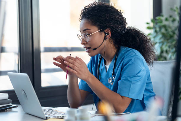 istock Attractive afro female doctor talking while explaining medical treatment to patient through a video call with laptop in the consultation. 1304749111