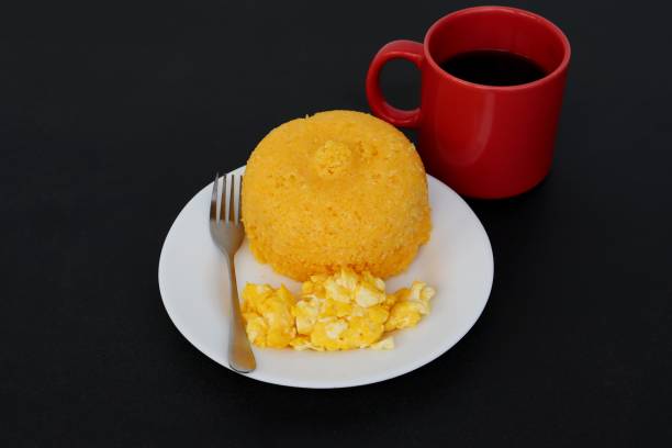 istock Brazilian Couscous (Cuscuz Brasileiro) and scrambled eggs on black background. Breakfast concept. 1304750088