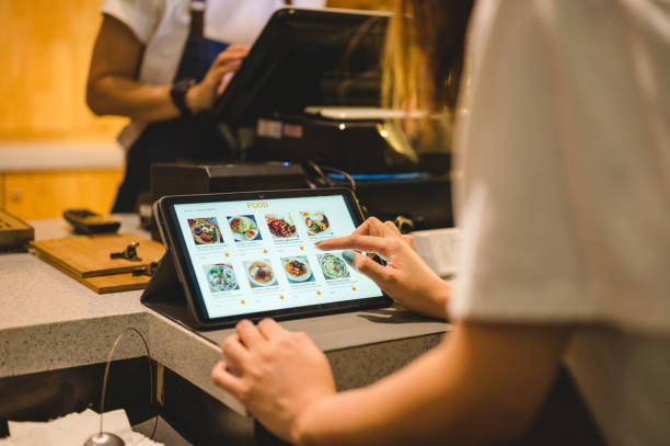 Female customer buying food on digital tablet at cashier counter Close-up of hand young Asian woman use digital tablet to buying food on digital tablet at cashier counter. ordering stock pictures, royalty-free photos & images