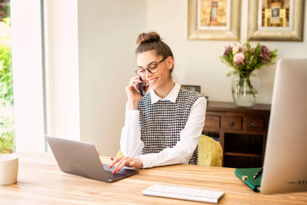 istock Young businesswoman making a phone call and using laptop while working from home 1304754207