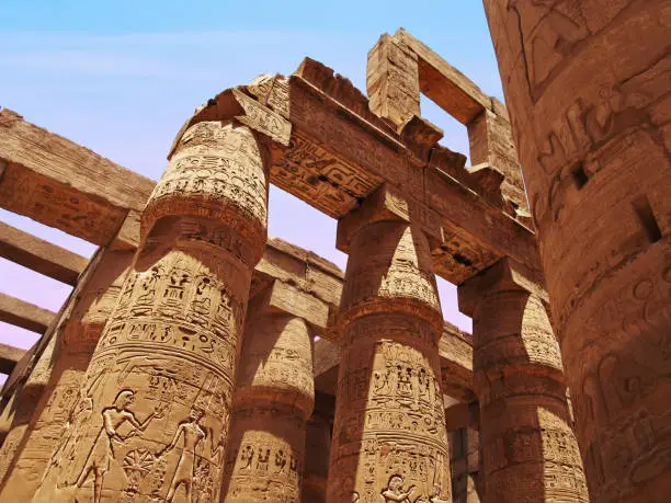 Columns and pylons of a roofless columned hall in Karnak temple complex near Luxor, Egypt.