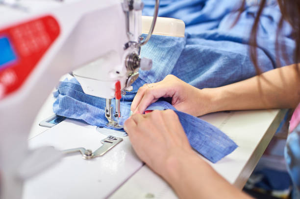 istock Industrial sewing machine and hand seamstress. Close-up. 1304755855