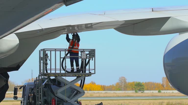 Airport airplane crew refueling aircraft on airline by technical staff maintenance ground. Preparing airplane for departure, repair of aircraft service worker use fuel hose on aircraft wing, on stairs