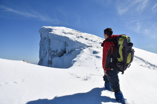 istock Man on top of snowy mountain 1304760065