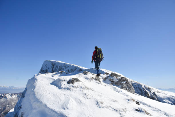 istock Man on top of snowy mountain 1304760517