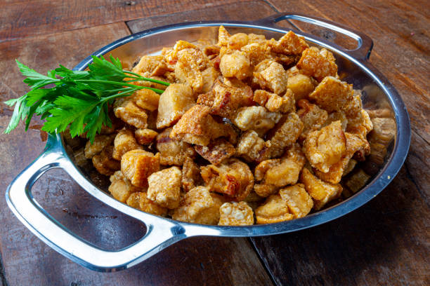 pork rinds (torresmo) on rustic wooden table in restaurant. typical dish of Brazilian and Asian cuisine