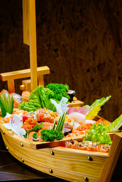 istock Sushi sashimi set in a wooden boat on a brown 1304761679