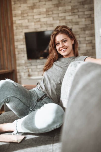 istock Smiling Female Beauty Sitting On Sofa At Home 1304761813