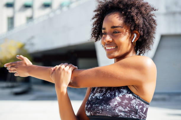 istock Afro athletic woman stretching arms before exercise. 1304762120