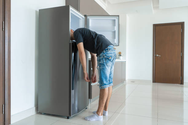 istock On a hot day, the guy cools with his head in the refrigerator. Broken air conditioner 1304762936
