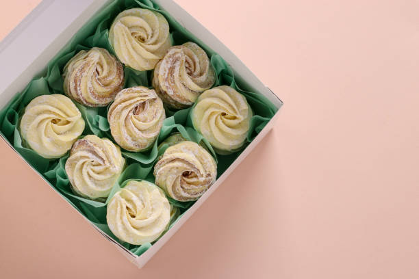 istock Homemade zephyr or marshmallows in a box on a pink background, Top view 1304763536