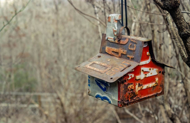 istock Birdhouse made with various old license plates hanging from a tree. 1304763861